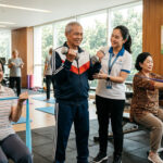 Seorang lansia melakukan latihan penguatan otot menggunakan dumbbell ringan sebagai upaya mencegah sarcopenia dan menjaga metabolisme tubuh.